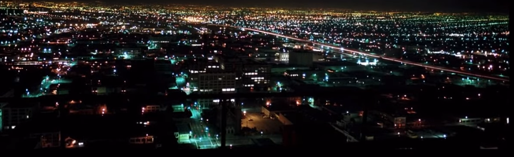 The LA skyline at night, slightly lengthened exposure turning the motion of cars in the street into streaks of light